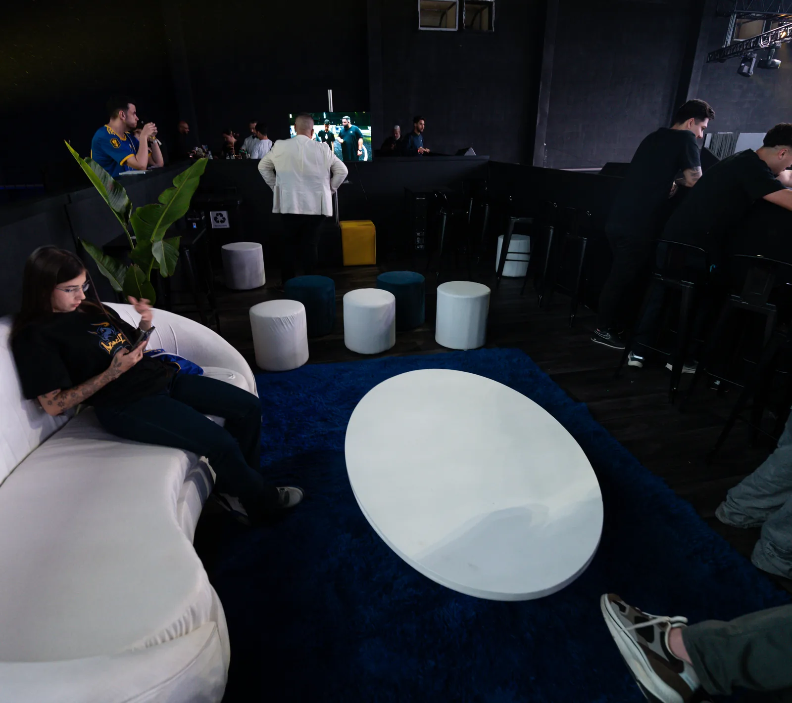 Lounge do camarote com poltronas brancas e tapete azul