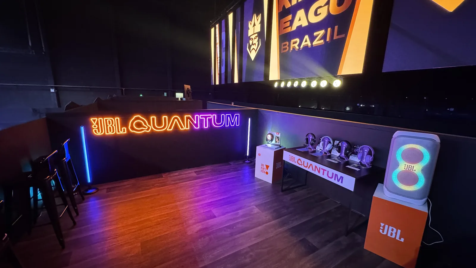 Camarote montado com neon JBL Quantum, mesa de headsets e PartyBox
